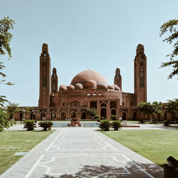 Beautiful view of the Grand Jamia Mosque in Lahore with clear skies and greenery.